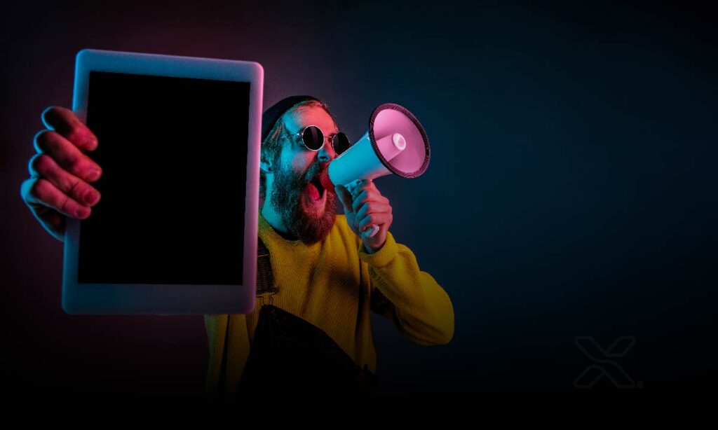 Anúncios on-line - Cara segurando um tablet e gritando no megafone